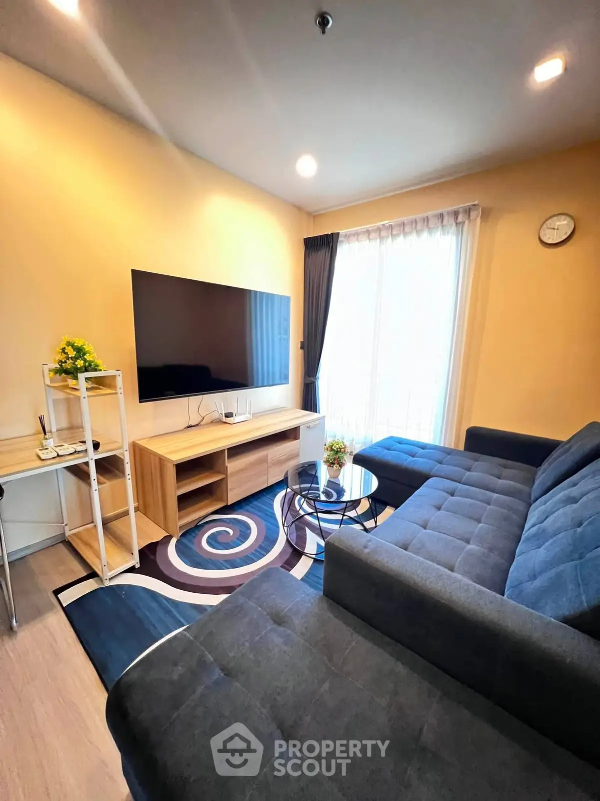 Modern living room with stylish furniture and large TV, perfect for relaxation and entertainment.