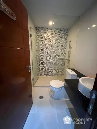 Modern bathroom with stylish mosaic shower tiles, sleek fixtures, and a spacious layout, perfect for a refreshing start to the day.