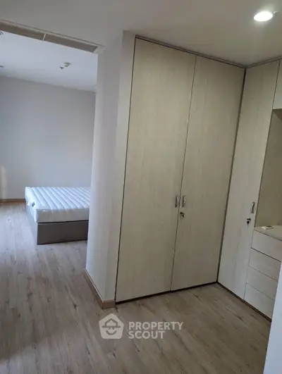 Modern bedroom with wooden flooring and built-in wardrobe