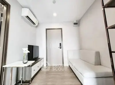 Modern living room with sleek furniture and air conditioning unit.