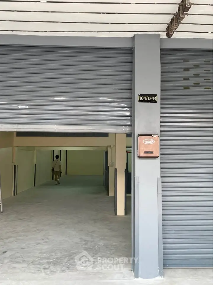 Spacious garage or storage unit with metal shutters and ample space for vehicles or storage needs.