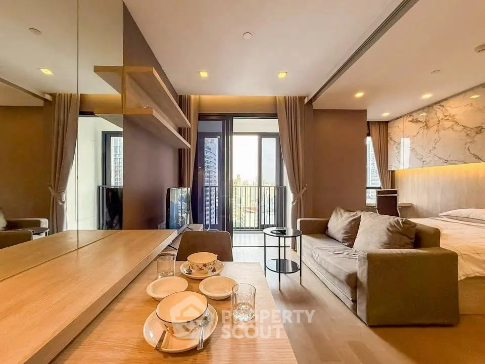 Modern living room with cozy sofa and elegant decor, featuring a small balcony view.