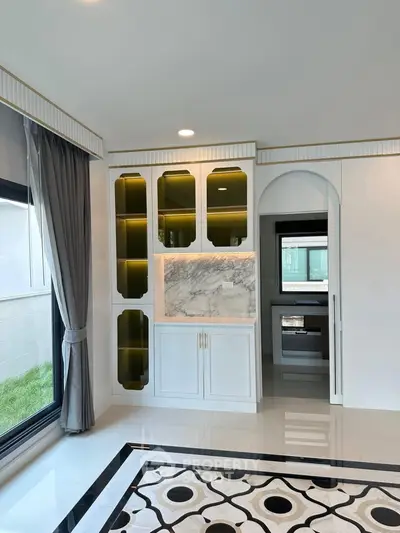 Luxurious living room with elegant built-in cabinets and modern kitchen view
