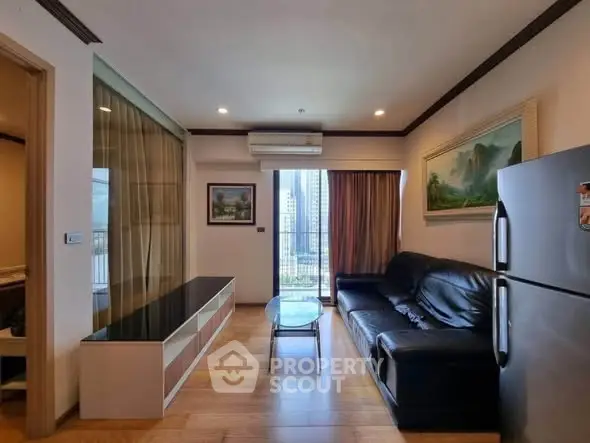 Modern living room with city view, sleek black sofa, and elegant decor in a high-rise apartment.