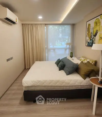 Modern bedroom with stylish decor and large window offering natural light