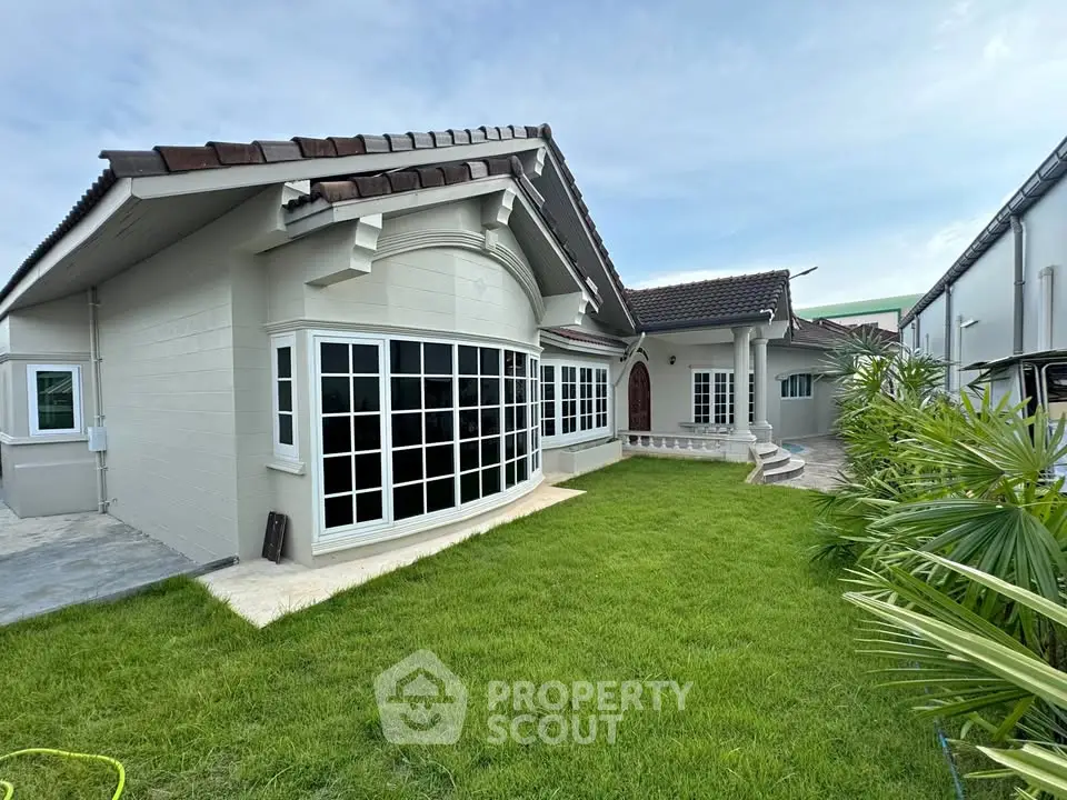 Charming single-story home with lush green lawn and elegant windows