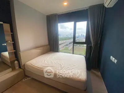 Modern bedroom with large window offering stunning city view, featuring sleek design and cozy ambiance.