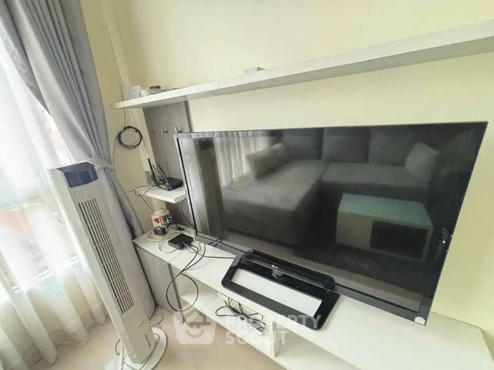 Modern living room with sleek TV setup and cozy sofa, perfect for relaxation and entertainment.