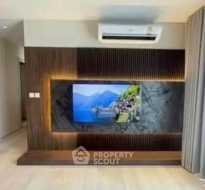 Modern living room with stylish TV wall and air conditioning unit.