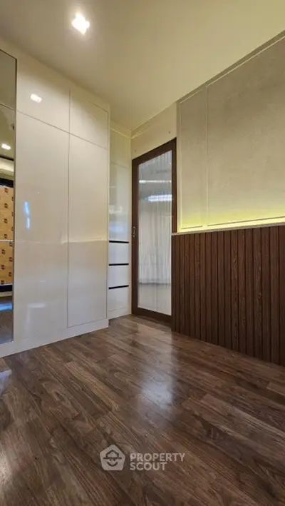 Modern interior with wooden flooring and sleek white cabinetry