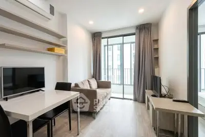 Modern living room with sleek furniture and large windows offering natural light.