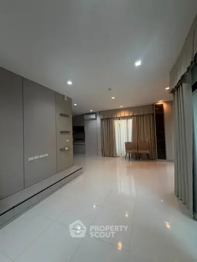 Spacious modern living room with elegant lighting and large windows for natural light.