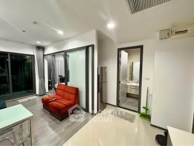 Modern open-plan living room with sleek kitchen and balcony access in a stylish apartment.