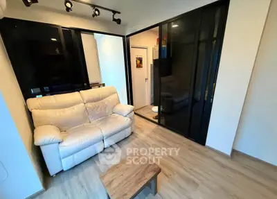 Modern living room with sleek black sliding doors and cozy white sofa.