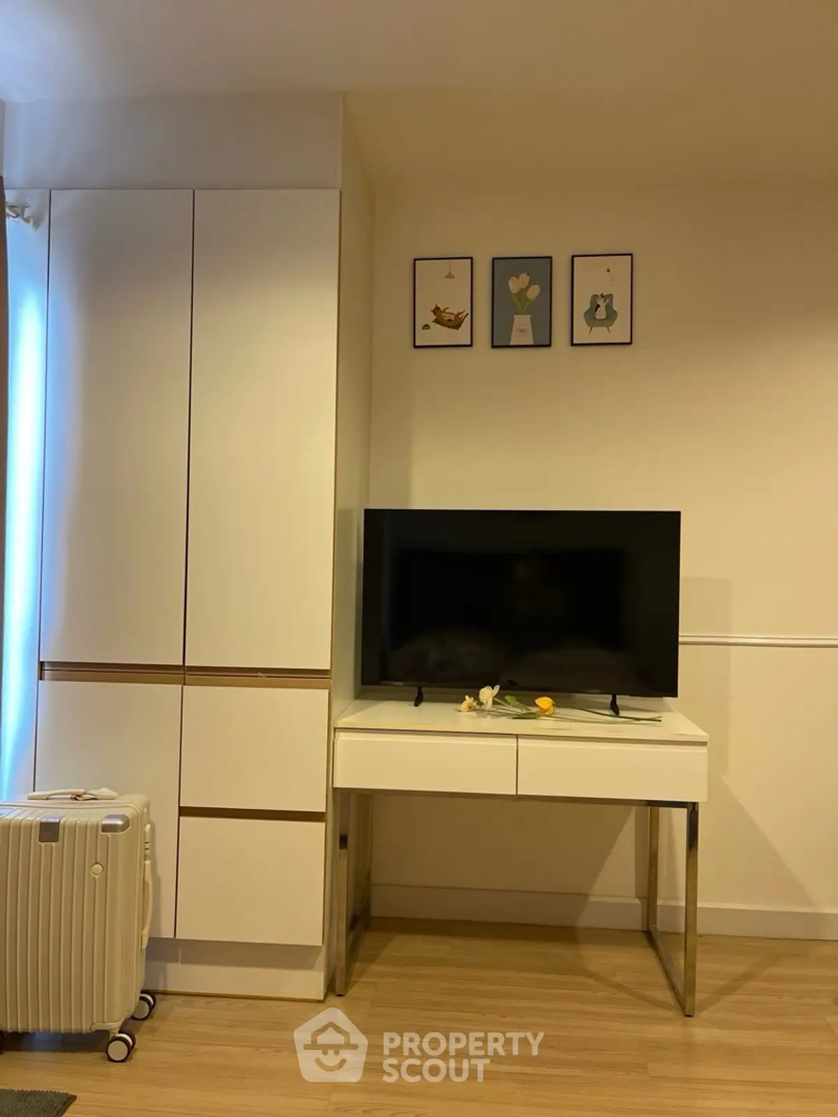 Modern living room with sleek TV stand and stylish wall art, showcasing contemporary interior design.