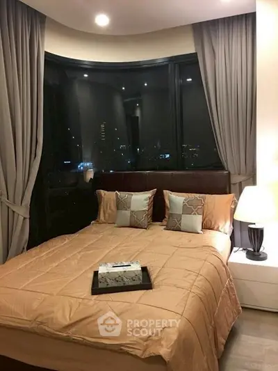 Luxurious bedroom with city view, elegant decor, and ambient lighting.