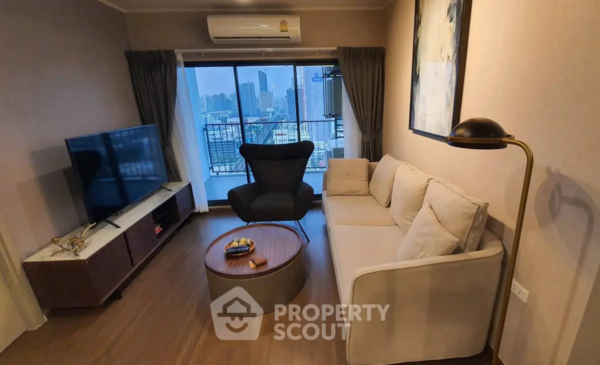 Modern living room with city view, stylish furniture, and cozy ambiance in high-rise apartment.