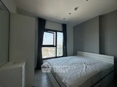 Modern bedroom with large window offering city view, featuring a sleek bed and minimalist decor.