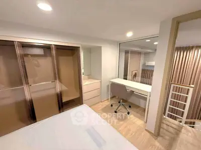 Modern bedroom with study area and built-in wardrobe in a stylish apartment.