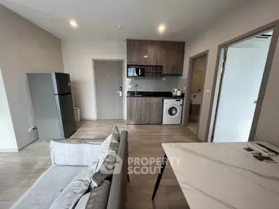 Modern apartment interior with open kitchen and living area, featuring sleek appliances and contemporary design.