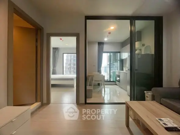 Modern apartment interior with open kitchen and living area, featuring sleek design and natural light.