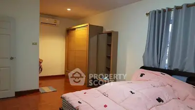 Cozy bedroom with wooden flooring and modern wardrobe in a stylish apartment.