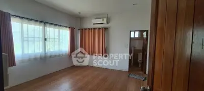 Spacious empty room with wooden flooring and natural light