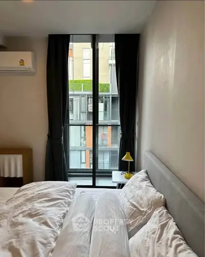 Cozy bedroom with large window and modern decor in urban apartment