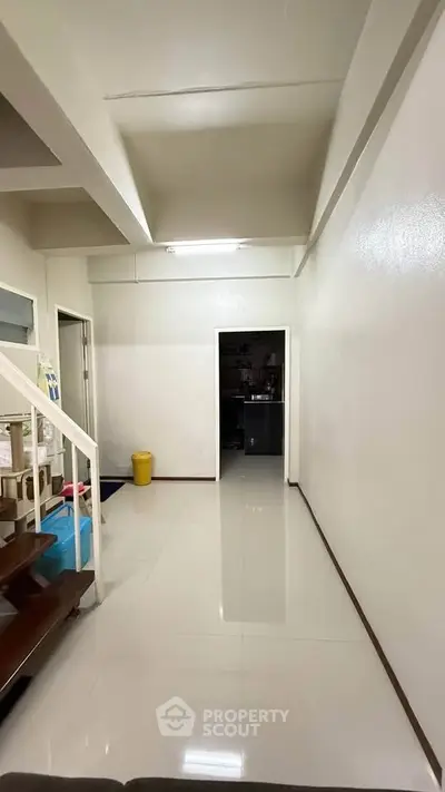 Spacious interior hallway with modern staircase and glossy tiled floor