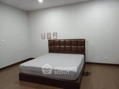 Spacious bedroom with modern bed frame and minimalist decor, perfect for relaxation.