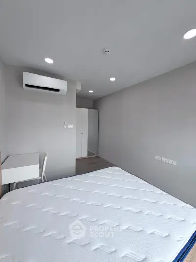 Spacious modern bedroom with air conditioning and ample storage space.