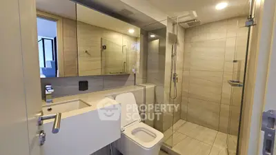 Modern bathroom with sleek design, glass shower, and elegant fixtures in a contemporary apartment.