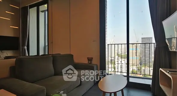 Modern living room with city view and large windows in urban apartment.