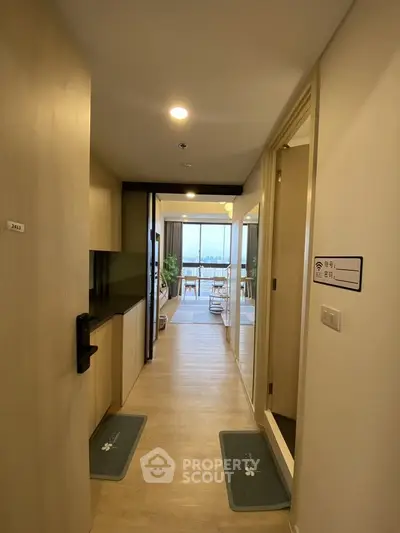 Modern apartment hallway leading to a bright living area with a stunning view.