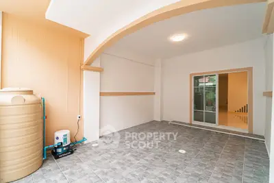 Spacious covered parking area with tiled flooring and water storage tank