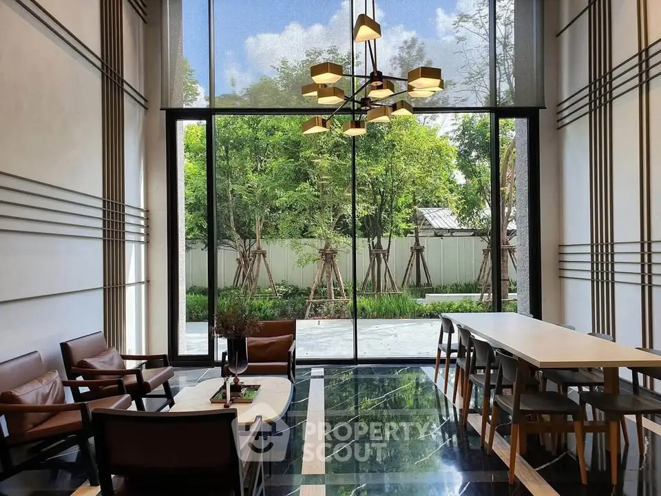 Luxurious modern living room with floor-to-ceiling windows and elegant furniture overlooking a lush garden.