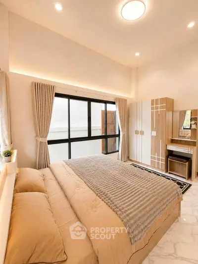 Luxurious bedroom with elegant decor and large window offering natural light