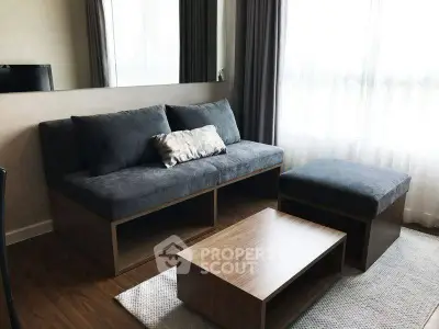 Modern living room with stylish sofa and wooden coffee table, featuring elegant curtains and natural light.