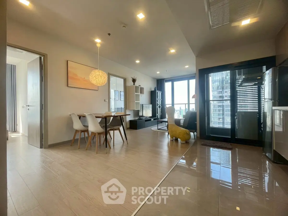 Spacious modern living room with open layout and city view, featuring elegant dining area and stylish decor.