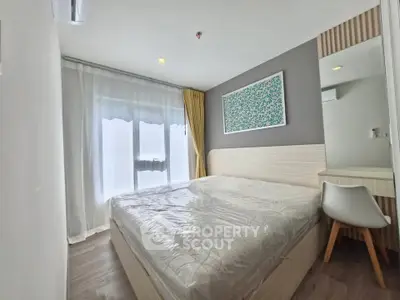 Modern bedroom with stylish decor and natural light, featuring a comfortable bed and sleek furnishings.
