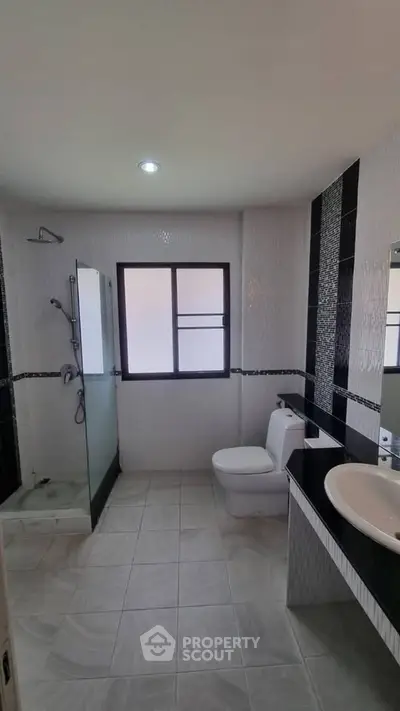 Modern bathroom with glass shower and sleek black countertop