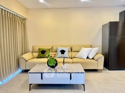 Modern living room with beige sofa, stylish coffee table, and sleek refrigerator, perfect for contemporary living.