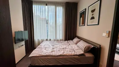Modern bedroom with large window and stylish decor in a contemporary apartment.