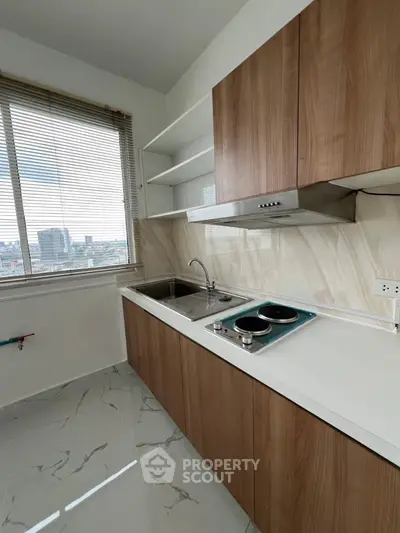 Modern kitchen with sleek cabinetry and city view window