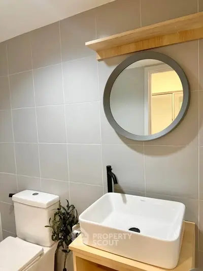 Modern bathroom with stylish sink and round mirror
