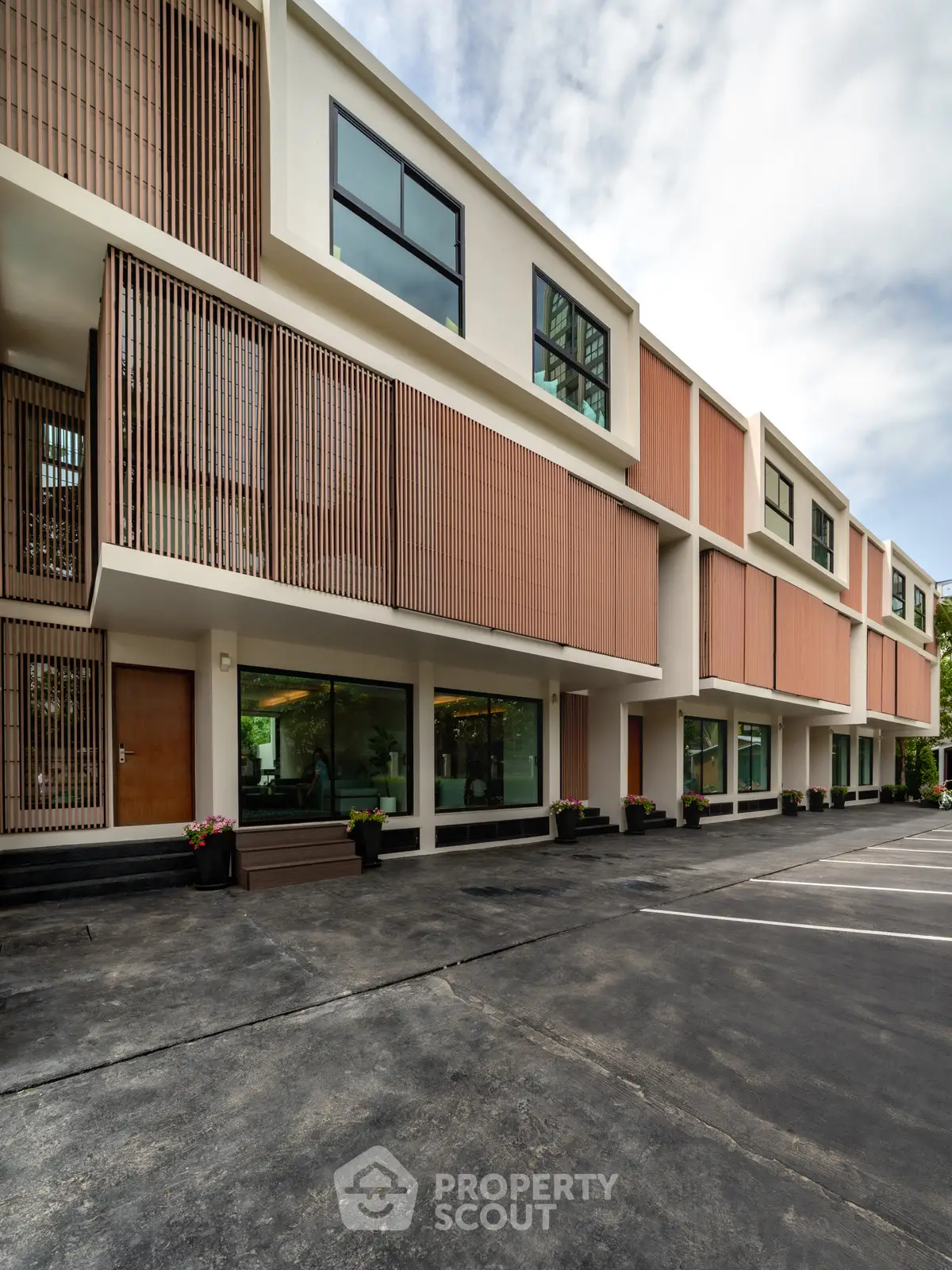 Modern townhouse exterior with unique architectural design and ample parking space.