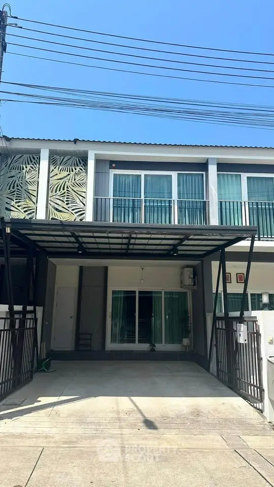 Modern two-story townhouse with a sleek facade and spacious driveway, perfect for urban living.