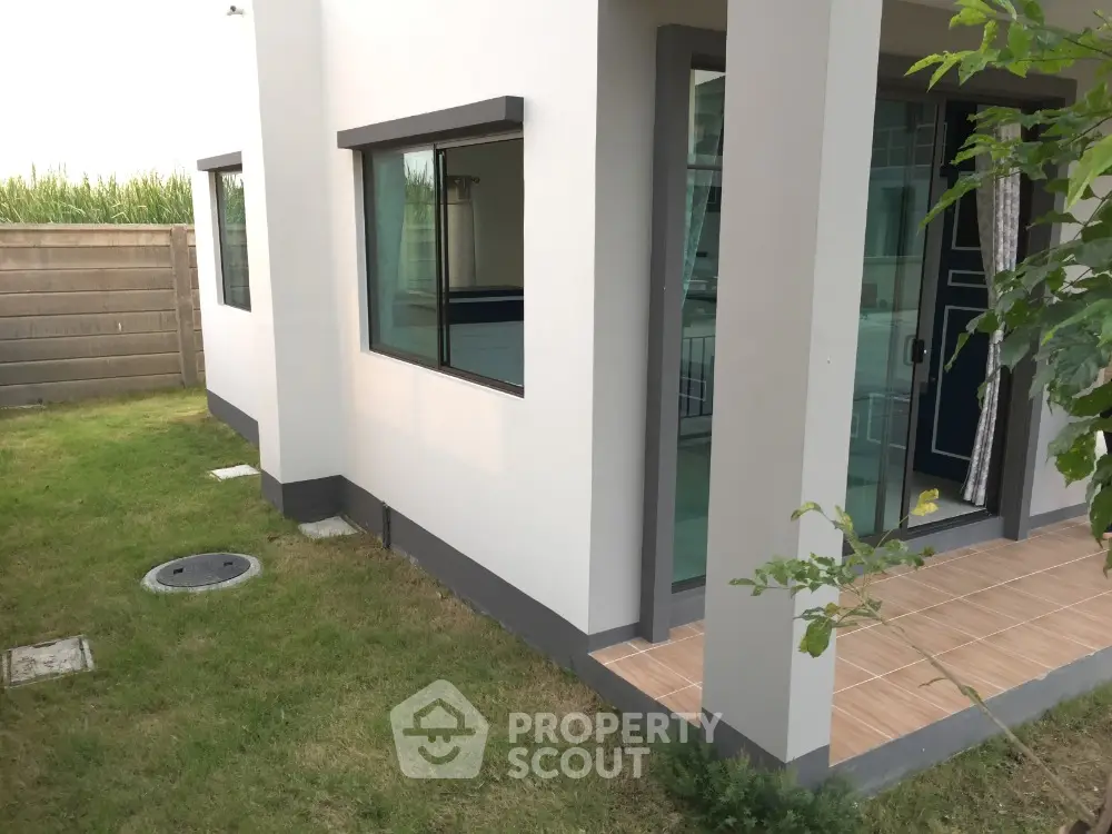 Modern house exterior with lush green lawn and large windows