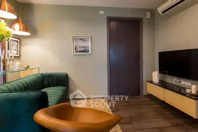 Stylish modern living room with green sofa, leather chair, and wall-mounted TV in cozy apartment.