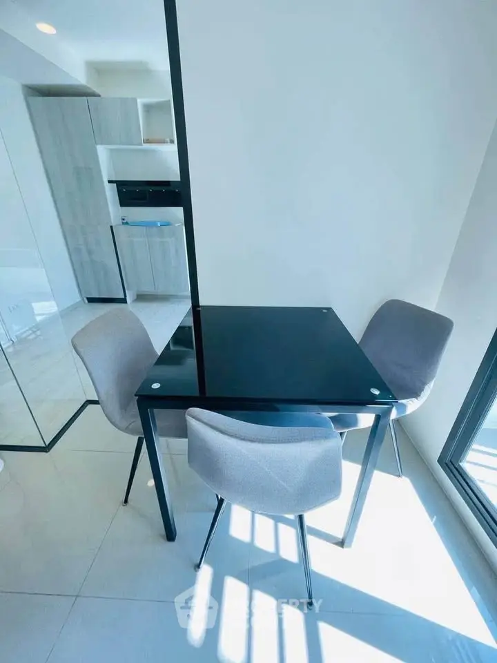 Modern dining area with sleek black table and stylish chairs in a bright, contemporary apartment.